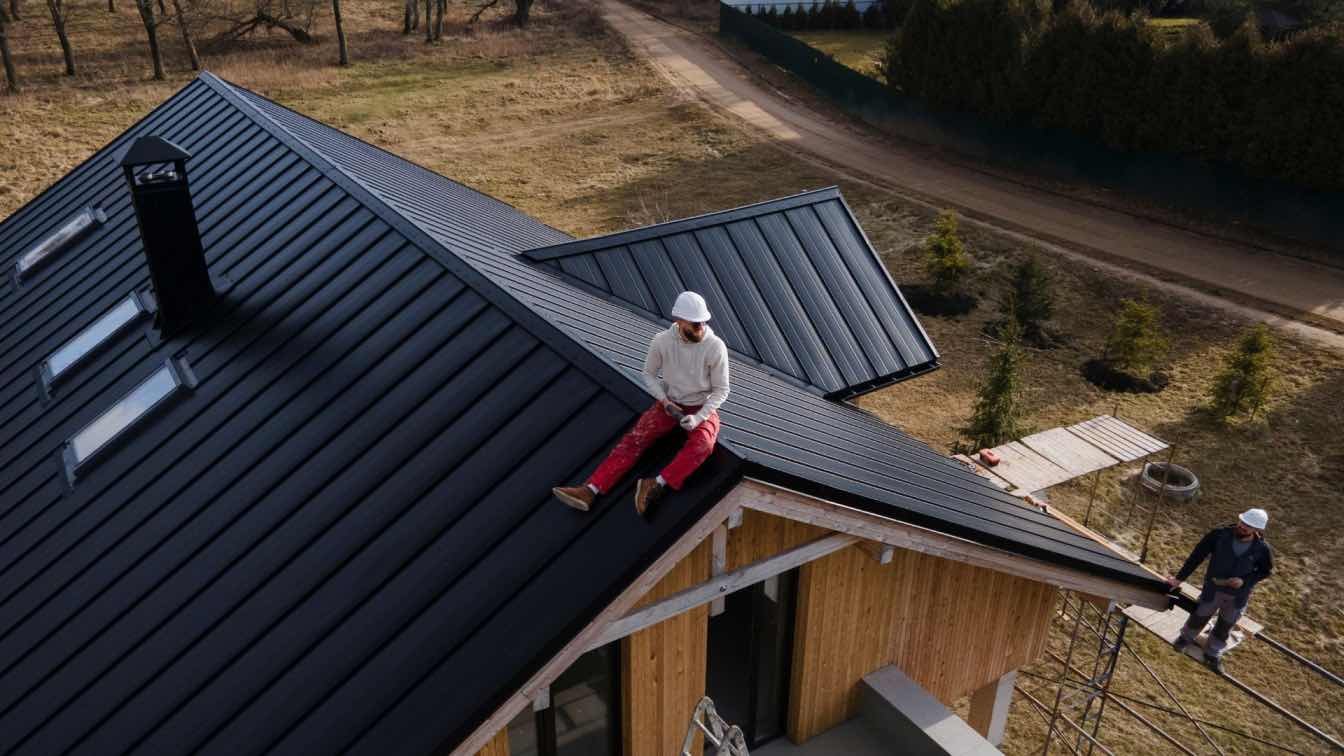 man-with-helmet-sitting-roof